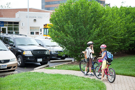 男孩骑自行车上学摄影照片_孩子们骑自行车上学