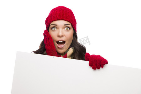 戴着冬帽和手套的震惊女孩举着空白牌子