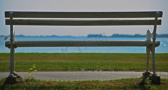 空荡荡的白色长凳望着远处的草地和湖泊