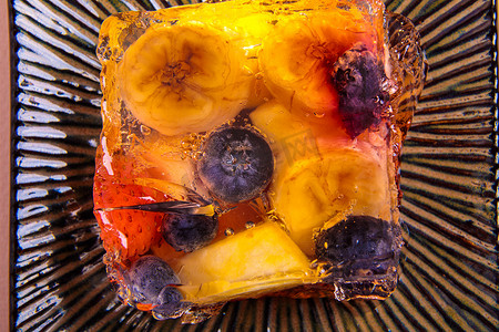 方形碟子上不同水果和浆果的果冻。
