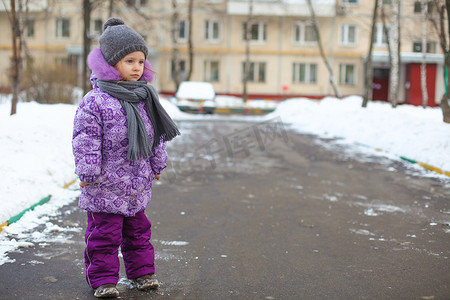 雪地里散步摄影照片_阳光明媚的冬日，在雪地里散步的可爱快乐小女孩