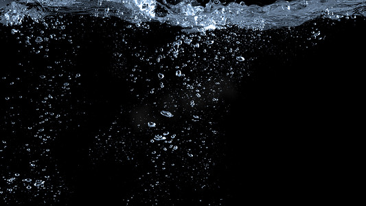 名仁苏打水摄影照片_黑色背景中苏打气泡飞溅的模糊图像