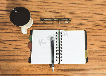 日记页摄影照片_桌子上有打开的笔记本，上面有空白页、眼镜、笔和一杯咖啡。