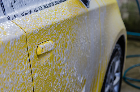 污垢摄影照片_有泡沫的黄色汽车。