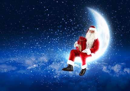 装饰月亮摄影照片_坐在月亮上的圣诞老人照片