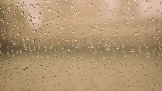 彩色雨滴背景摄影照片_雨季湿窗玻璃表面的雨滴。