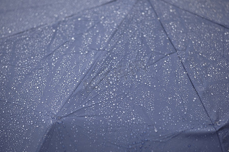 防水雨伞摄影照片_雨打在雨伞上