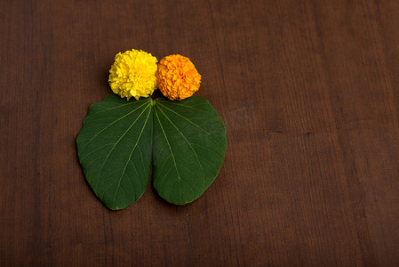 印度节日 Dussehra，在棕色背景上展示金叶（紫荆花）和万寿菊花。