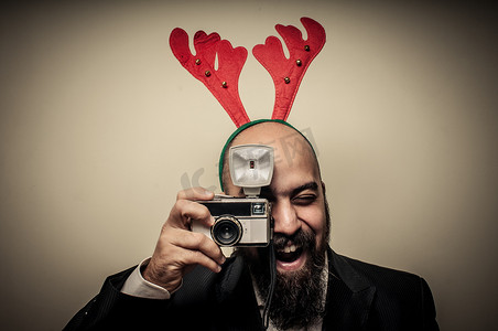 老旧的照片摄影照片_拿着老照相机的圣诞节有胡子的人