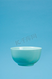 一个蓝色陶瓷哑光深碗早餐在蓝色 bac 上飞行