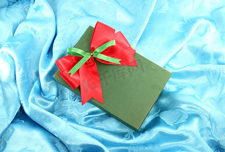 蓝色缎带上带红丝带的绿色礼盒