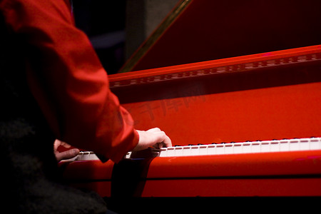 红色乐谱摄影照片_红色钢琴钢琴家的手