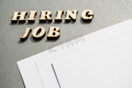 Hiring JOB 是用灰色背景上的木制字母写的，接近白纸，设计布局，广告布局，招聘概念