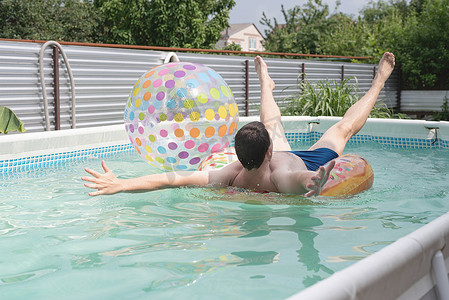 游泳管摄影照片_年轻人在充气游泳管的游泳池里玩得开心