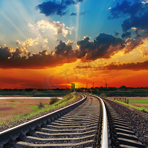 黄昏路上摄影照片_铁路上的红色日落到地平线