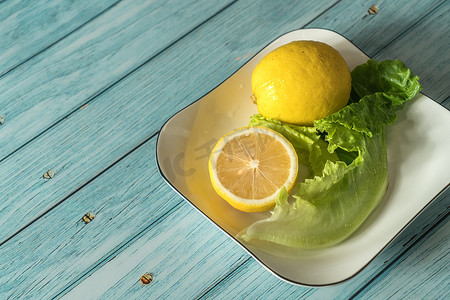 水果蓝摄影照片_蓝桌上的水果柠檬，凉爽的浅色背景