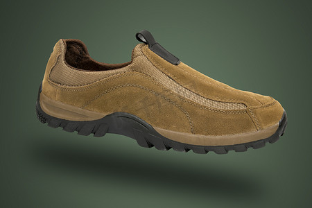 产品附件摄影照片_绿色背景的男性棕色皮革运动鞋，孤立的产品。