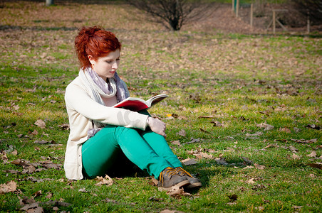 公园看书的红长发女孩