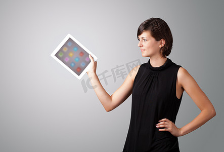 app彩色摄影照片_拿着带有彩色图标的现代平板电脑的女人