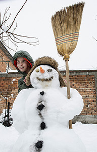 下雪院子里摄影照片_雪人和孩子在院子里