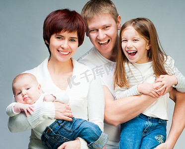 看照相机的俏丽的微笑的家庭