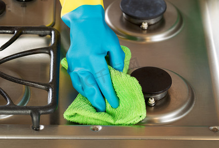 戴手套的手用绿色超细纤维 ra 擦拭炉顶范围