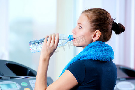 女性喝水摄影照片_健身房喝水的女人