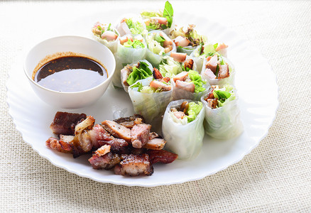 越南春卷摄影照片_新鲜什锦亚洲春卷配烤猪肉、新鲜蔬菜