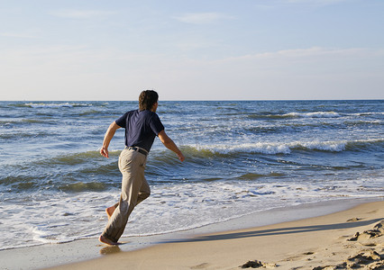 海边活动摄影照片_沿着海边奔跑的人