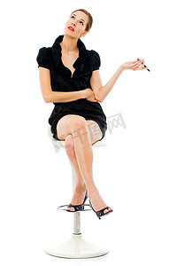 聪明的年轻女人坐在凳子上拿着手机