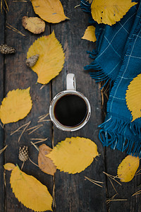 秋天公园的一张旧木桌上放着一杯茶咖啡。