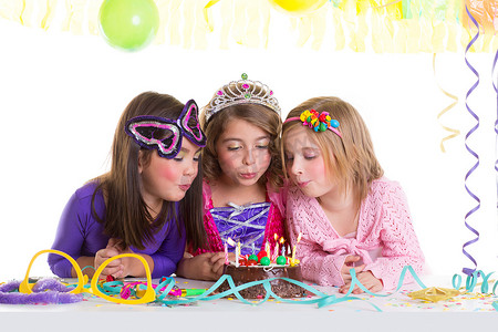 孩子们快乐的女孩吹生日派对蛋糕