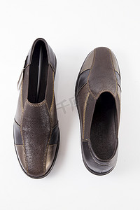 一双白色背景的棕色皮鞋，孤立的产品，顶视图。