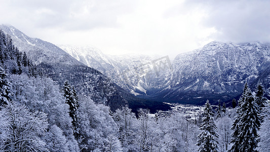 梦幻景观摄影照片_哈尔施塔特冬季雪山景观山谷和湖泊穿过高地山谷森林的风景梦幻景观通往奥地利哈尔施塔特老盐矿