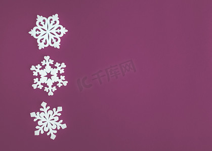 圣诞假期作文，顶视图白色雪花装饰在紫色粉红色背景上，带有文本复制空间。
