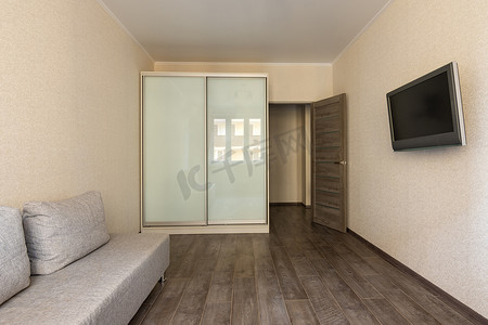 空调客厅摄影照片_旅馆、电视、衣橱和沙发的一间小房间的内部