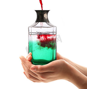 白色背景中手持红色和绿色液体的瓶子