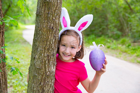 有大紫色鸡蛋和滑稽兔耳朵的复活节女孩