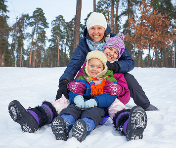 滑稽的家庭在冬天风景雪橇