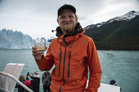 南极洛摄影照片_在阿根廷埃尔卡拉法特的佩里托莫雷诺冰川喝冰川威士忌