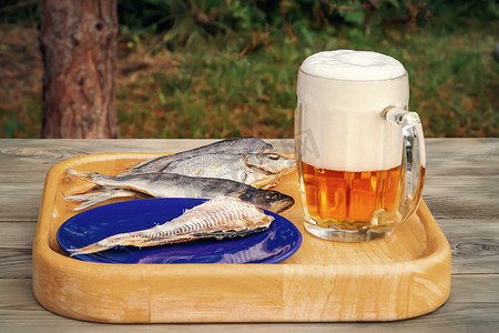 夏日户外木桌上放着一杯淡啤酒和干鱼 — 照片，图片