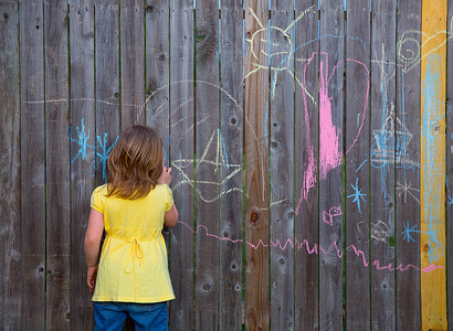金发小女孩在后院玩画粉笔
