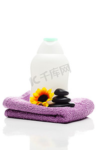 温泉石摄影照片_隔离的化妆品容器、花、毛巾和黑色温泉石