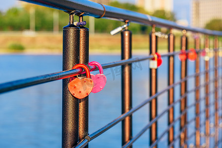 金属锁摄影照片_挂在栏杆上的金属锁。
