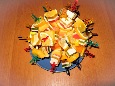 红色宝剑摄影照片_由水果糖和柠檬制成的多色甜点