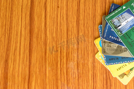 堆放在木桌边缘的不同银行信用卡。