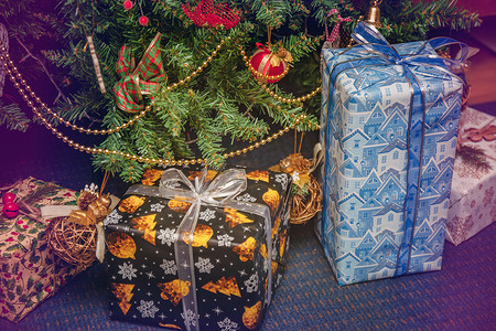 喜庆松树摄影照片_装饰喜庆的圣诞树下，各种包装好的礼物。