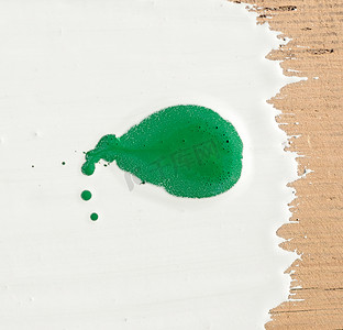 白色背景上绿色油漆滴的特写