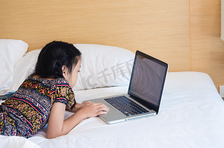 躺在床上玩电脑的女孩