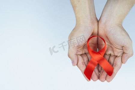 艾滋病意识，男性手拿着红色艾滋病意识丝带